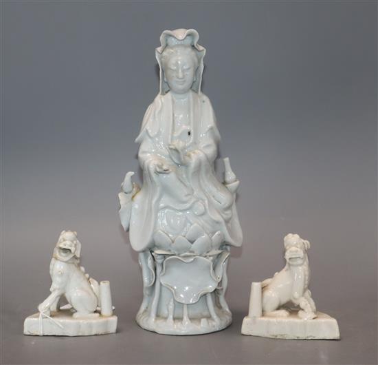 A Chinese blanc de chine figure of Guanyin and a pair of lion dog joss-stick holders, faults and a Chinese porcelain